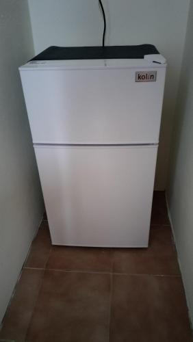 a white refrigerator sitting in a corner of a room at 水源棧 in Fengyuan