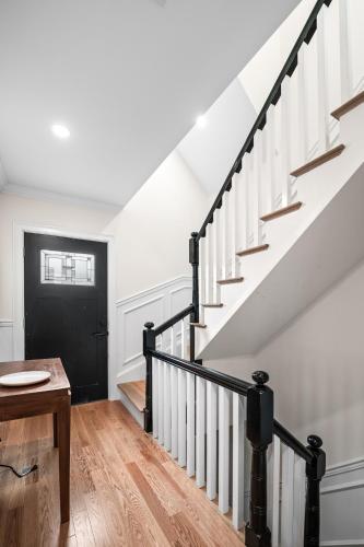 a hallway with stairs and a black door at Forest Hill condos -Boston in Boston