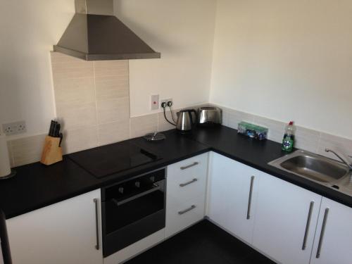 a kitchen with a black counter top and a sink at Aberdeen Serviced Apartments - Bloomfield in Aberdeen