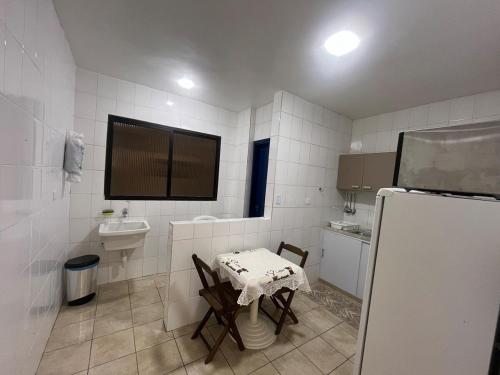 eine kleine Küche mit Tisch und Spüle in der Unterkunft Ap 700m Praia Enseada-TV Smart, Garagem-Elevador in Guarujá