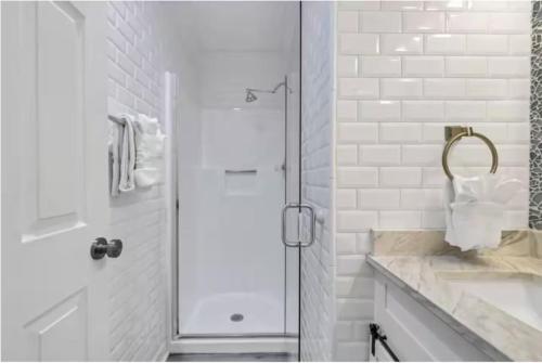 a white bathroom with a shower and a sink at Salty Beach Getaway! in Destin