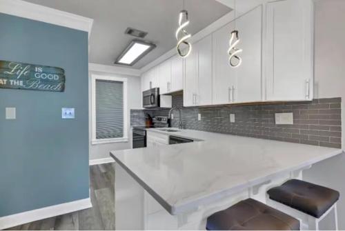 a kitchen with white cabinets and a white counter top at Salty Beach Getaway! in Destin