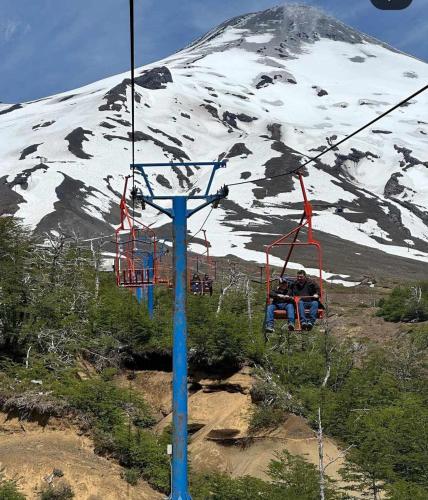 a ski lift in front of a snow covered mountain at Pucón Volcano Forest SPA in Pucón
