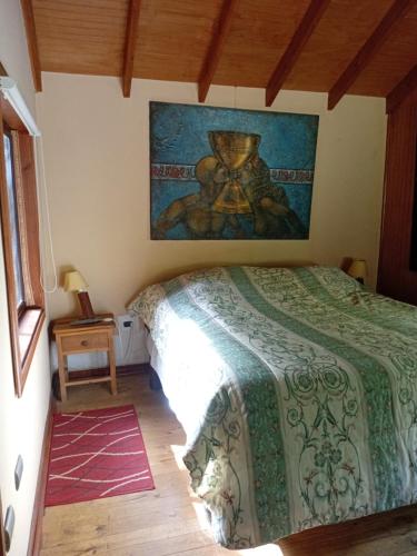 a bedroom with a bed and a painting on the wall at Pucón Volcano Forest SPA in Pucón
