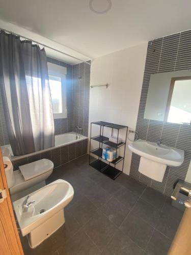 a bathroom with two sinks and a tub and two toilets at Chalet Calpe mar y peñón in Calpe