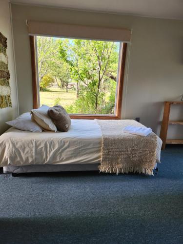 a bed in a bedroom with a large window at Casa Bordemar in Castro
