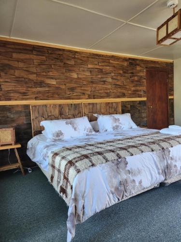 a bedroom with a large bed with a wooden wall at Casa Bordemar in Castro