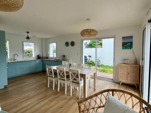 a kitchen and dining room with a table and chairs at Maison Neuve et Spacieuse Près du Port Tudy - FR-1-813-25 in Groix