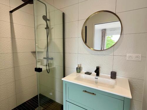 a bathroom with a sink and a shower with a mirror at Maison Neuve et Spacieuse Près du Port Tudy - FR-1-813-25 in Groix