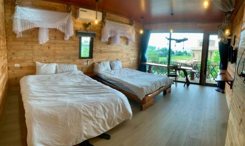 a bedroom with two beds and a balcony with a view at A Thía homestay in Diện Biên Phủ