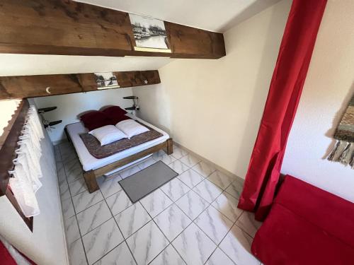 Cette petite chambre comprend un lit et un rideau rouge. dans l'établissement Pavillon à Vendres Plage pour 5 pers avec Terrasse - FR-1-781-98, à Vendres