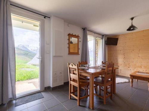 une salle à manger avec une table et une grande fenêtre dans l'établissement Studio cosy pour 4 près des pistes à Peyragudes - FR-1-695-76, à Gouaux-de-Larboust