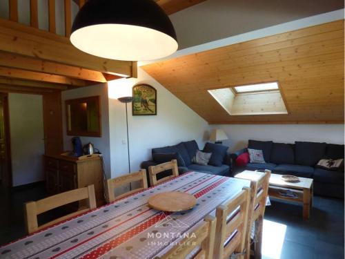 un salon avec une table et un canapé bleu dans l'établissement Duplex 4 pièces + mezzanine pour 8 personnes au Grand-Bornand - FR-1-458-227, au Grand-Bornand
