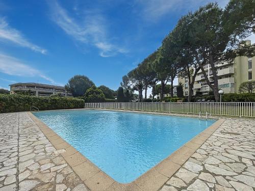 une piscine avec de l'eau bleue dans une cour dans l'établissement Studio lumineux à Antibes avec piscine, tennis et balcon - FR-1-789-10, à Antibes