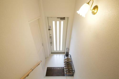 a hallway with a staircase with a door and a mirror at プラジールヤカ in Yaka