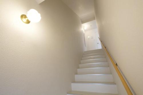 a staircase with a light on the wall and a stair case at プラジールヤカ in Yaka