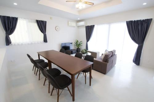 a living room with a wooden table and chairs at プラジールヤカ in Yaka