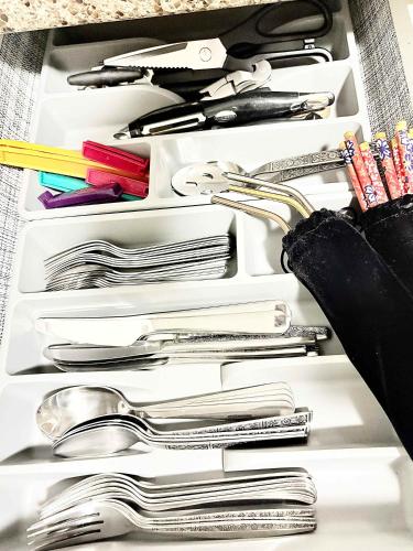 a drawer filled with lots of silver utensils at Stylish Downtown Condo near Rogers Place l Parking, Gym, Balcony & Kitchen in Edmonton