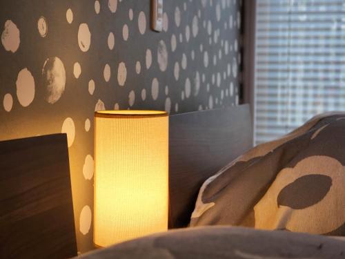 a lamp sitting on top of a bed next to a bed gmaxwell gmaxwell at タイピーハウス in Sado