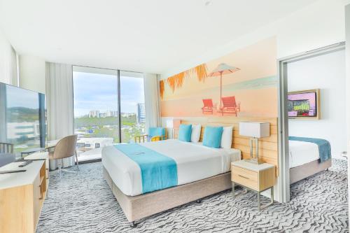 a hotel room with a bed and a desk at Rydges Gold Coast Airport in Gold Coast