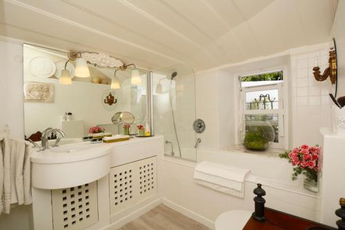 ein weißes Bad mit einem Waschbecken und einer Dusche in der Unterkunft Casa do Castelo in Lissabon