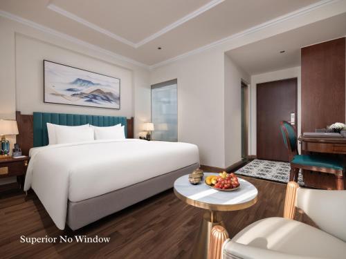 a hotel room with a large bed and a desk at L'Signature Hotel & Spa in Hanoi