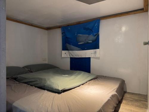 a bed in a room with a painting on the wall at 海的那一間Hostel By The Sea in Green Island