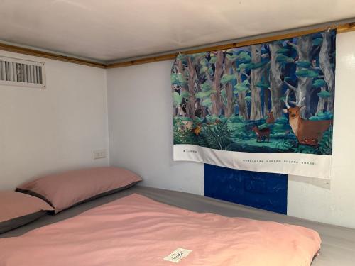 a bedroom with a painting hanging on the wall at 海的那一間Hostel By The Sea in Green Island