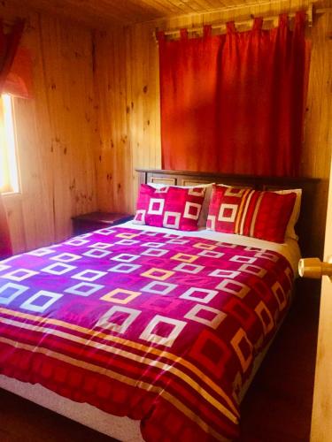 a bedroom with a bed with a red curtain at Mapunre in Malalcahuello