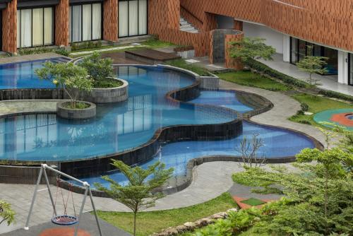 an image of a swimming pool in a building at Hotel Santika Premiere Linggarjati - Kuningan in Kuningan