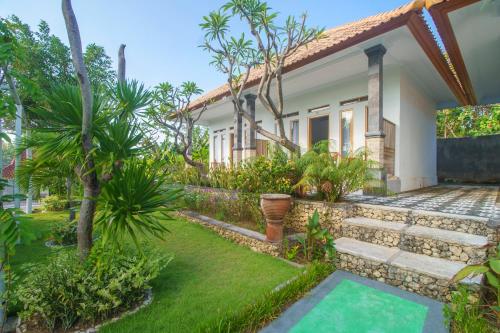 a villa with a garden and a house at Govardhan Nusa Penida in Nusa Penida