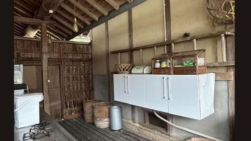 a kitchen with a white cabinet in a barn at nano inn in Kanagawa
