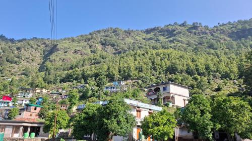 a group of houses on the side of a mountain at Akash Kamini Homestay in Chopta