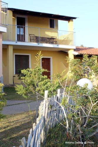 a yellow house with a fence in front of it at Hotel Belvedere in Teulada