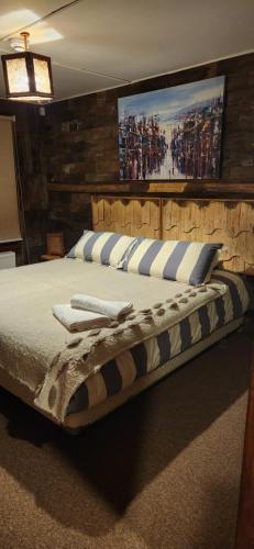 a bedroom with a large bed with a wooden wall at Casa Bordemar in Castro