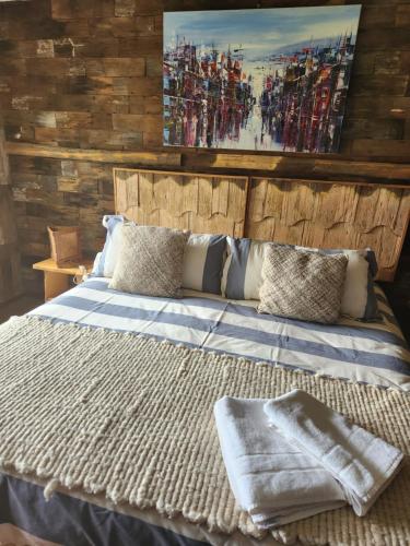 a bedroom with a large bed with a wooden wall at Casa Bordemar in Castro