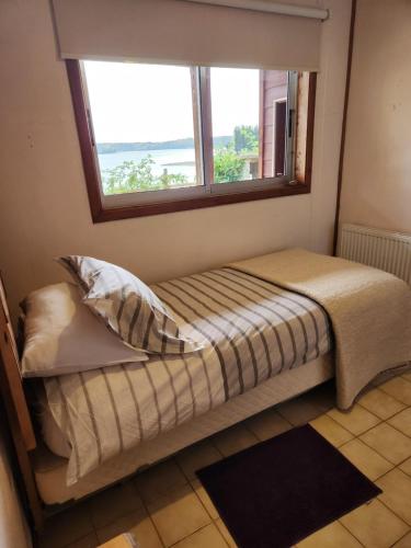 a bed in a room with a window at Casa Bordemar in Castro