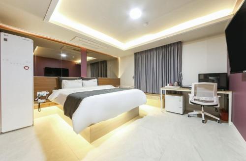 a bedroom with a bed and a desk and a computer at Gwangju Yeogijoa Hotel in Gwangju