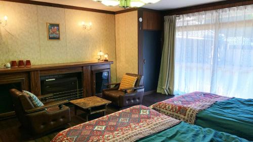 a hotel room with two beds and a chair at nano inn in Kanagawa