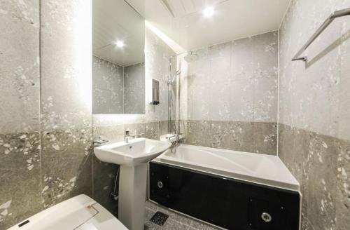 a bathroom with a sink and a tub and a toilet at Gwangju Yeogijoa Hotel in Gwangju