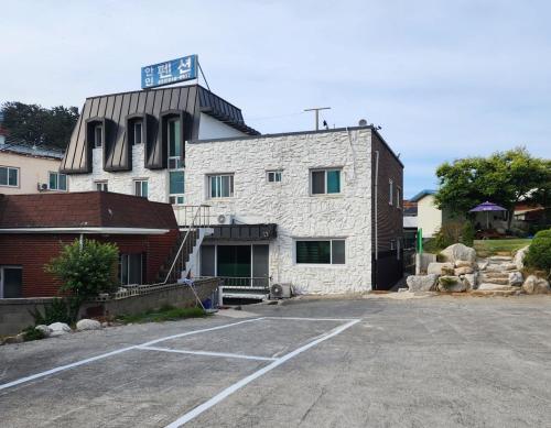 Un edificio con un estacionamiento enfrente. en Gangneung Anin Pension, en Gangneung