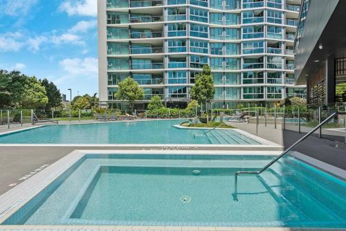 a swimming pool with a large building in the background at Sky High Hamilton in Brisbane