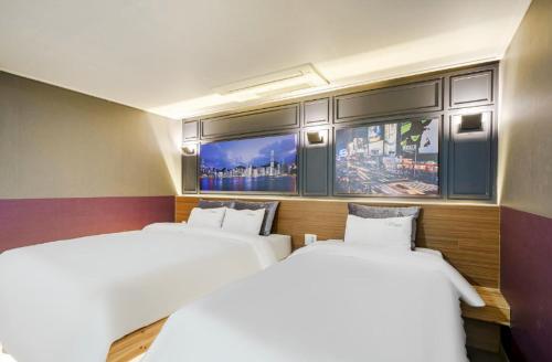 a room with two beds and a flat screen tv at Gwangju Yeogijoa Hotel in Gwangju