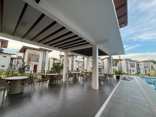 an outdoor patio with tables and chairs and a pool at A&T Residence-Panglao in Panglao