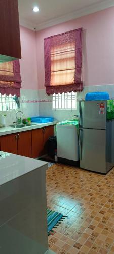 a kitchen with pink walls and a refrigerator in it at ASTANA INN HOMESTAY Balik Pulau in Balik Pulau