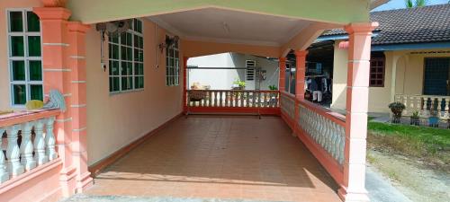 a front porch of a house with an orange and yellow at ASTANA INN HOMESTAY Balik Pulau in Balik Pulau