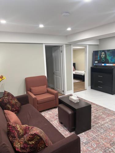 a living room with a couch and a chair and a television at Private 2bedroom Unit, Free Parking, Free from Smoke & Pet, Self-Check IN in Pickering