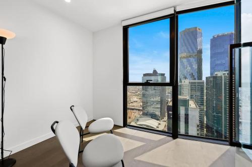 a living room with a view of a city skyline at Premier Tower - Modern CBD Apt 45th Floor home in Melbourne