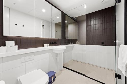 a bathroom with a tub and a sink and a mirror at Premier Tower - Modern CBD Apt 45th Floor home in Melbourne