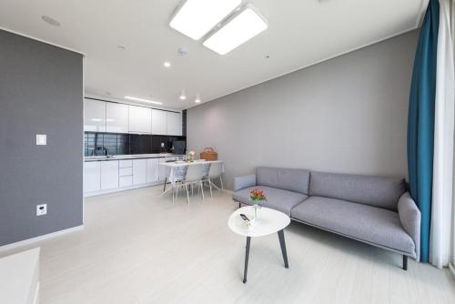 a living room with a couch and a table at Gangneung The Gangneung Ocean Stay Part4 in Gangneung